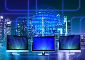 Bildschirme vor einer Skyline mit Linien als Zeichen des Datenverkehrs