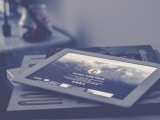 Bücher und ein Tablet sind übereinander gestapelt.