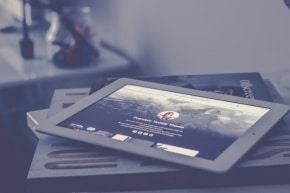 Bücher und ein Tablet sind übereinander gestapelt.