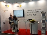 Das Bild zeigt eine Besucherin am Messestand.